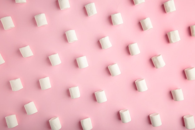 White marshmallows on a pink background