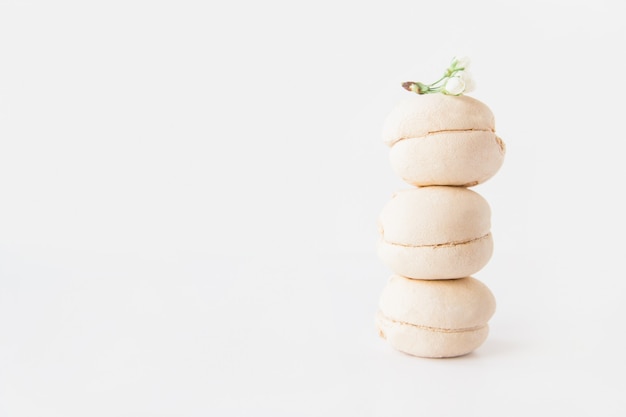 White marshmallows stack with a white flower on top on white background