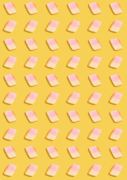 White marshmallows on a yellow background. geometric pattern of white marshmallows. top view