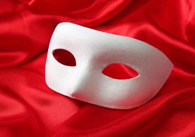 White mask, on red silk fabric