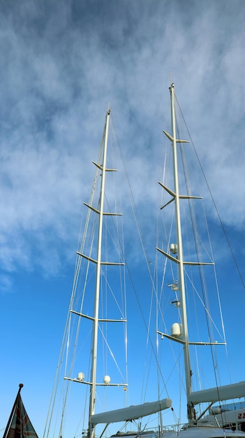 White masts of a large yacht against the blue sky