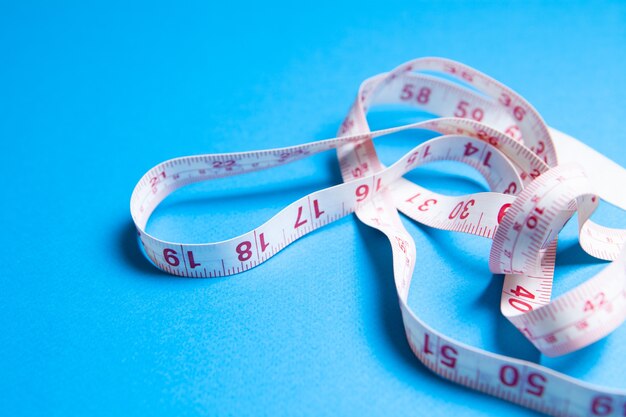 White measuring tape on blue surface