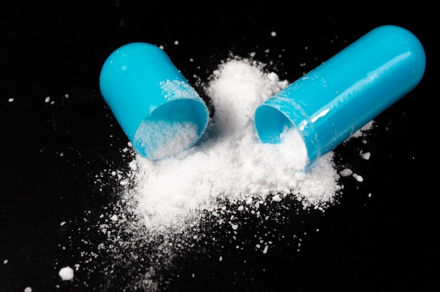 White medical pills and tablets on black background Closeup photo of medical preparations with copy space