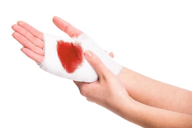 White medicine bandage on injured hand with blood.