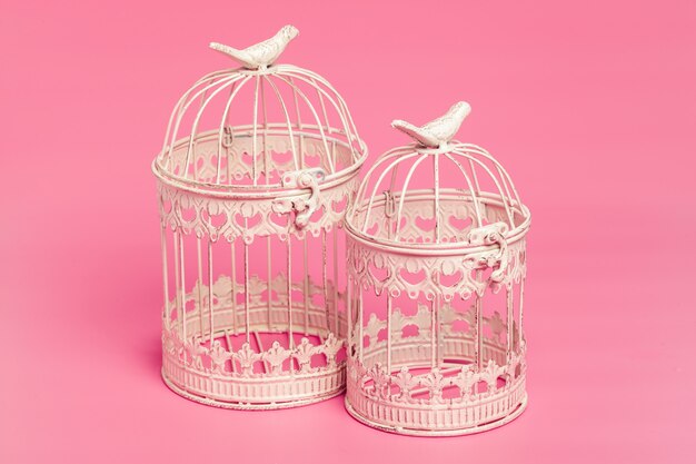 White metal decorative cages on colored pink background