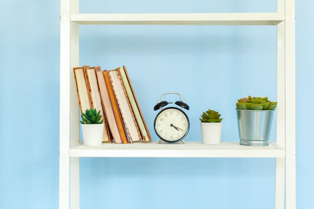 White metal rack with books against blue background