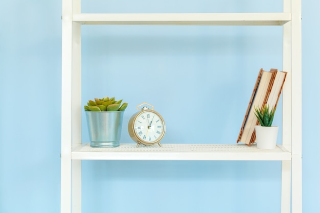 White metal rack with books against blue background