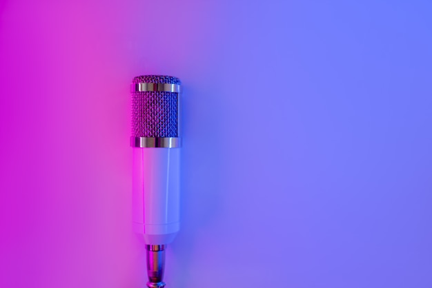 White metallic microphone on neon. 