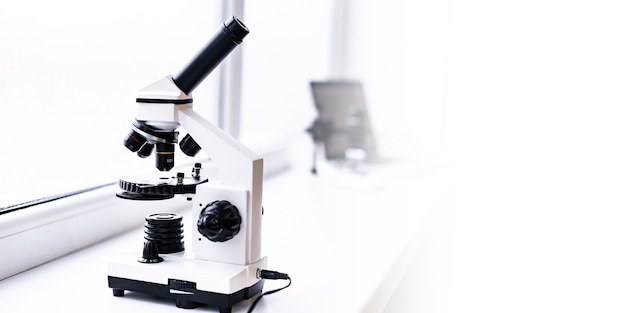 A white microscope on the table a scientific laboratory\
laboratory of medical sciences look through
