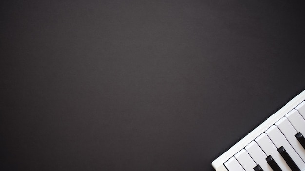 Photo white midi keyboard on a dark background flat lay top view