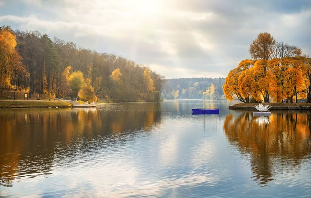 モスクワのツァリツィーノの池と秋の金の木のある公園の白いミニチュアボート