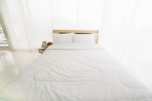 Interno camera da letto minimalista bianco al mattino con la luce solare.