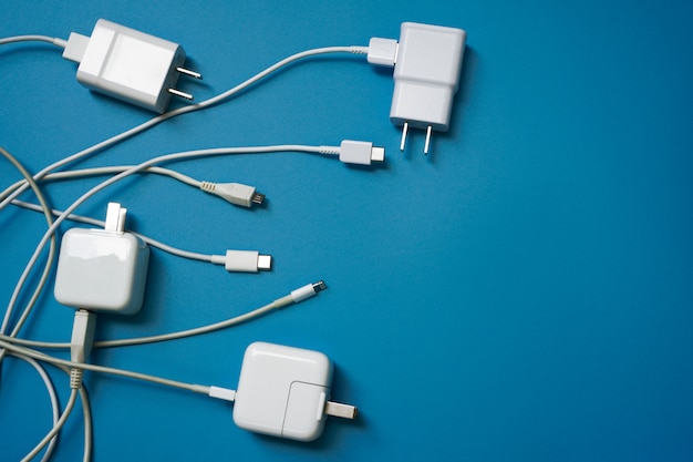 white mobile phone chargers with multiple type of USB on blue background