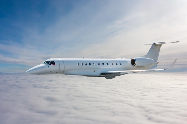 Белый современный роскошный частный самолет летит в воздухе над облаками
