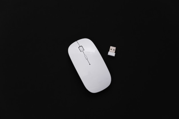 White modern wireless pc mouse on black background. Top view