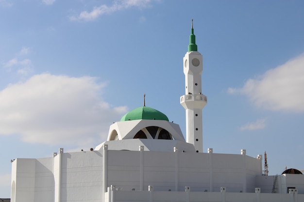 A white mosque with a green dome and a green dome.