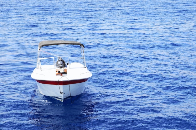 Foto barca a motore bianca con tenda in mare