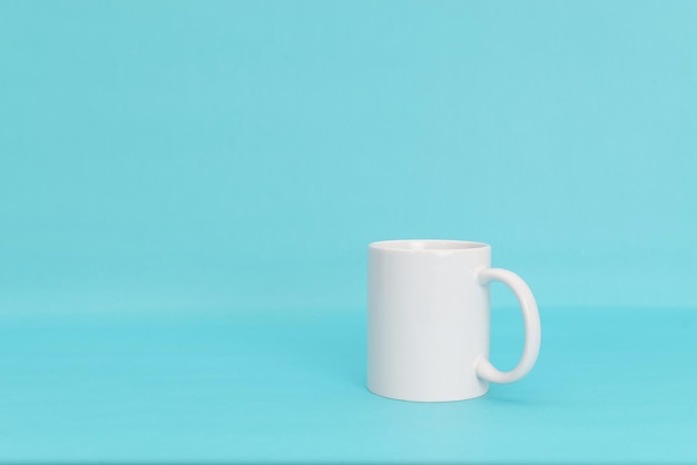 White mug on a blue background Mug isolated.