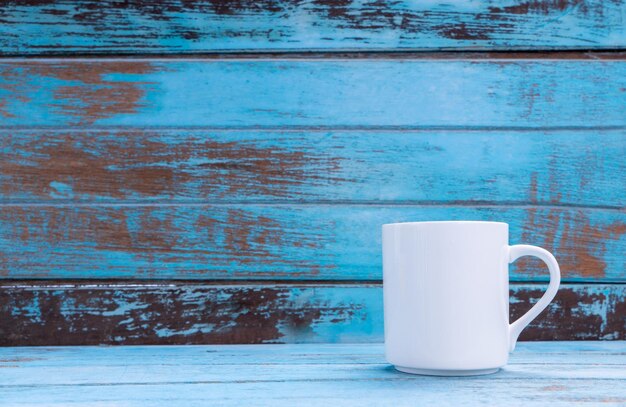 Foto coppa di caffè bianca su un tavolo di legno blu