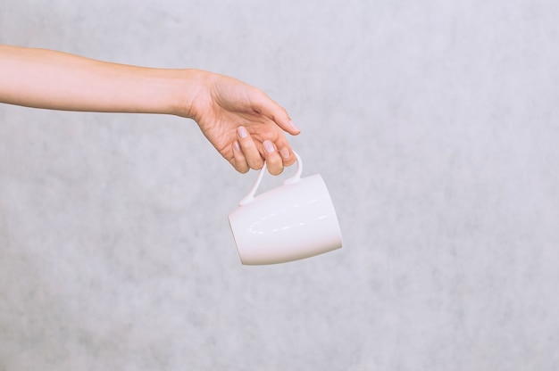 White mug for coffee, tea in the girl's hand. On a white background.