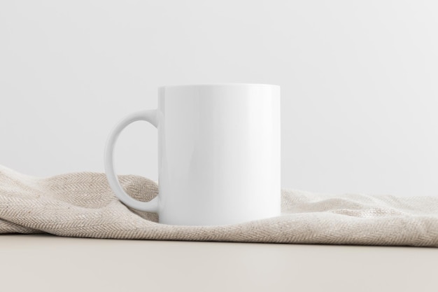 White mug mockup with a table cloth on a beige table