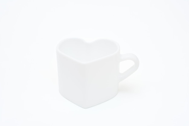 White mug in the shape of a heart on a white background