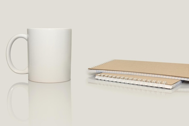 White mug for tea or coffee for breakfast notepad for writing\
on a white background