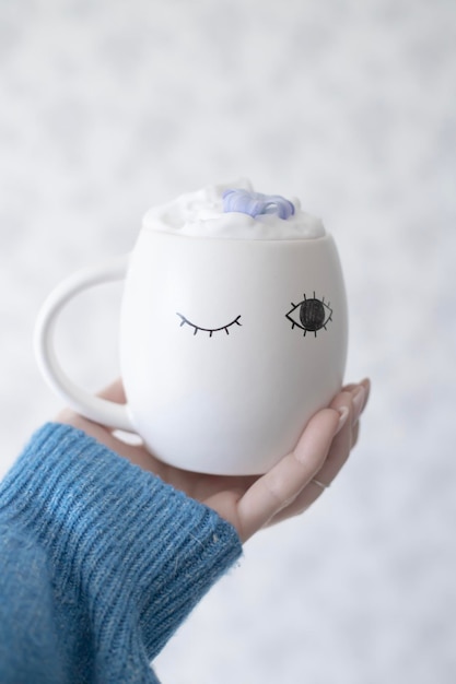 A white mug with a blue eye and a black eye on it.