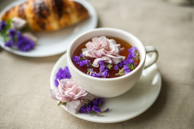 White mug with tea floating flowers