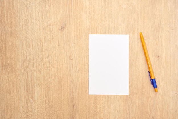 White note paper or cards and a yellow pen on a wooden table. Note banner. 