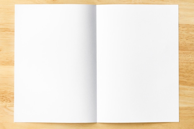 Foto pagine aperte del taccuino della carta di nota bianca sulla tavola di legno