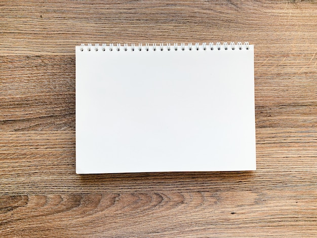 White notebook top view on wooden table