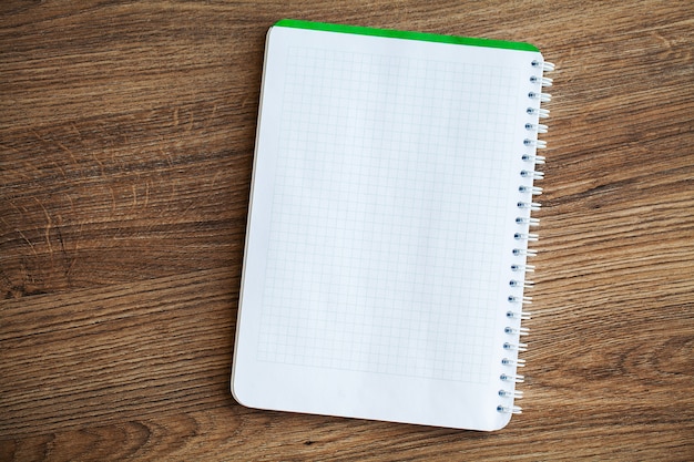 White notebook top view on wooden table.