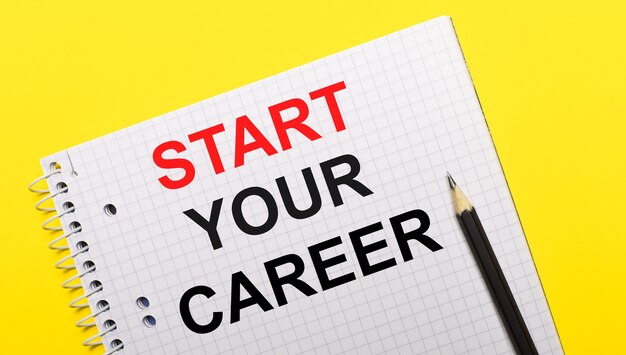 밝은 노란색 배경에 검은색 연필로 쓴 START your CAREER라는 글자가 있는 흰색 노트북.