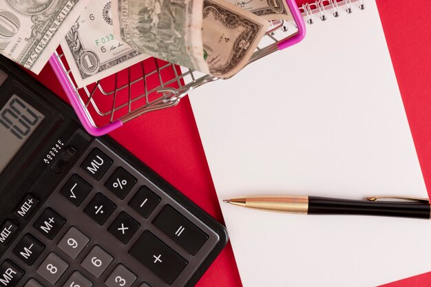 Photo white notepad with calculator and stylish pen on a red background. copy space.