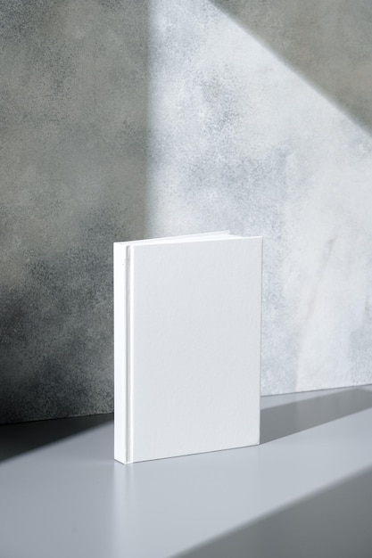 White notepad with hard cover on gray background