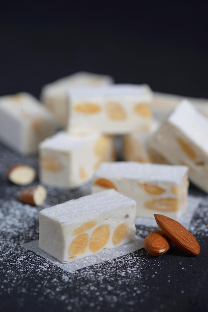 Photo white nougat with almonds on black ardesia plate