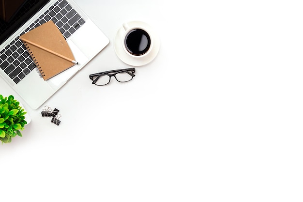 White office desk table with blank notebook computer keyboard\
and other office supplies top view with copy space flat lay