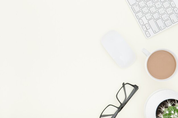 White office desk table with laptop, cup of coffee and supplies. Top view with copy space.