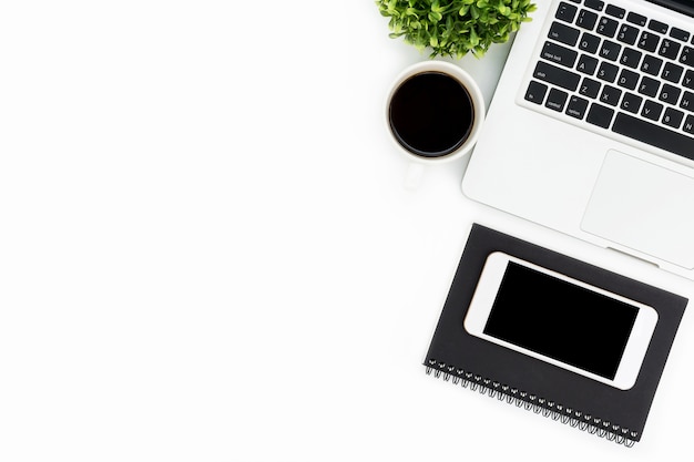 White office desk table with laptop, smartphone, coffee and supplies. 