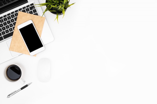 White office desk table with laptop, smartphone, cup of coffee and supplies.