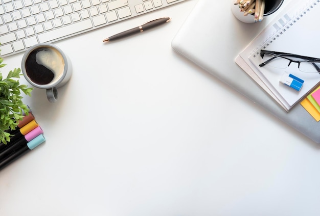 White office desk with notepad sticky notes glasses and coffee cup Top view with copy spacex9