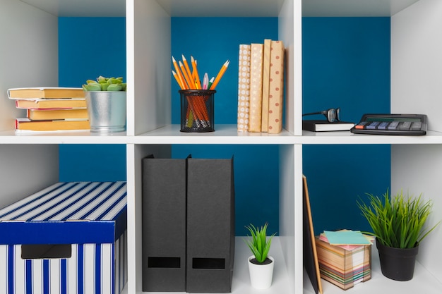 Photo white office shelves with different stationery, close up