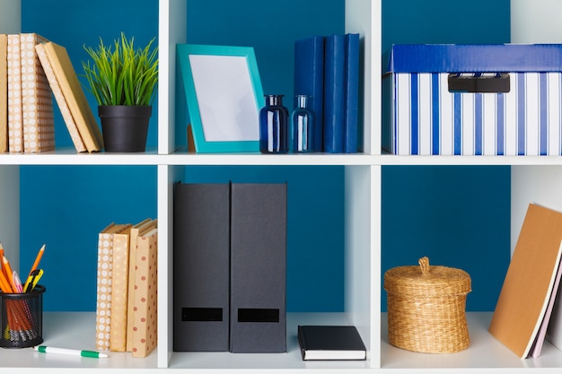 Photo white office shelves with different stationery, close up