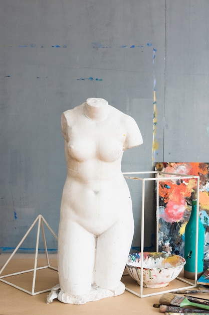 white old broken female statue and painting equipment