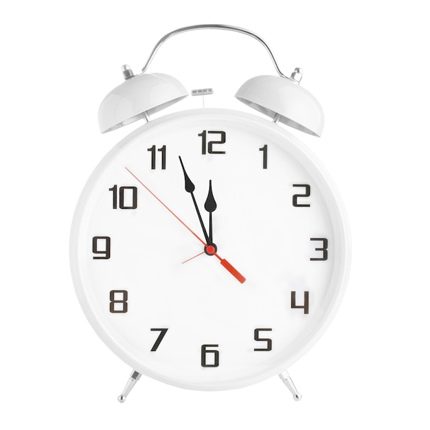 White oldfashioned alarm clock showing five minutes to twelve oclock isolated on white background