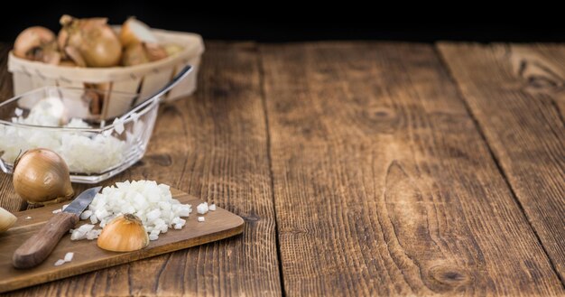 White Onions dices on wooden background selective focus