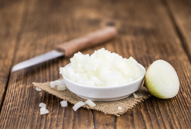 White Onions dices on wooden background selective focus