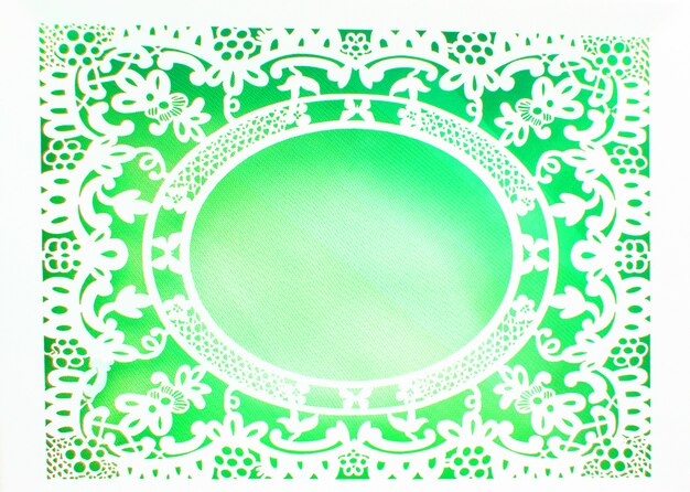 Белая ажурная кружевная овальная бумажная рамка в роскошном стиле на зеленом фоне