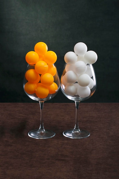 White and orange balls in two large glasses